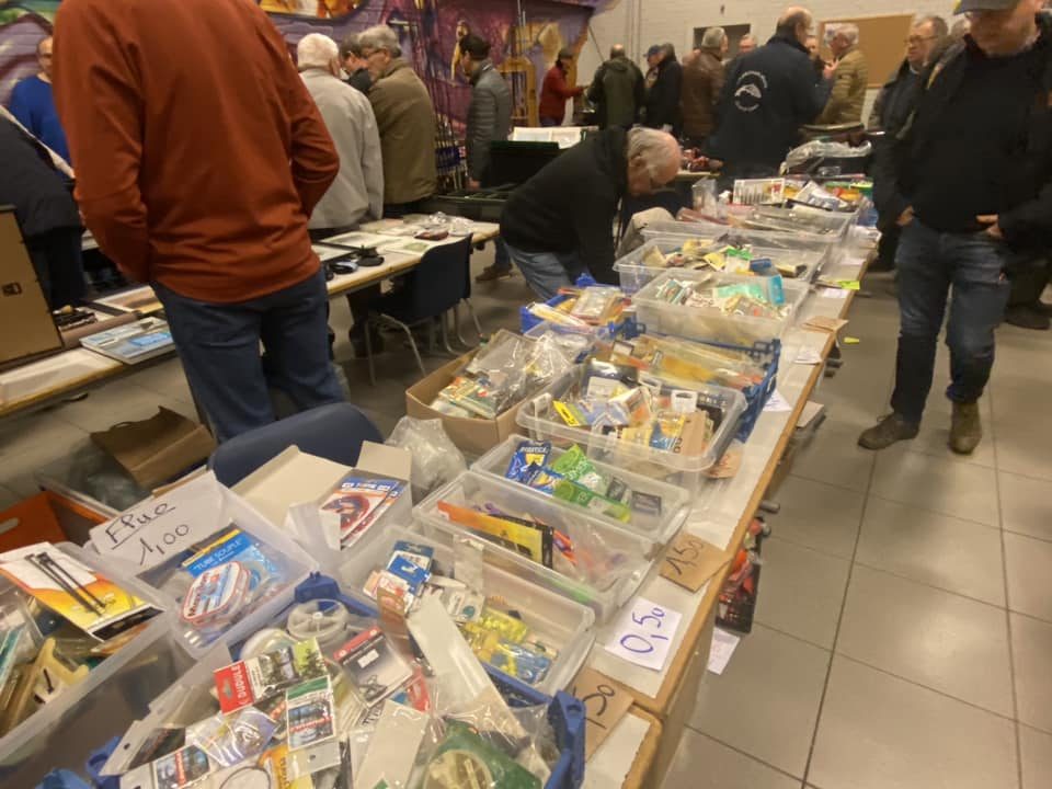 Visiteurs dans les all?es de la Bourse, devant des tables couvertes de mat?riel de p?che